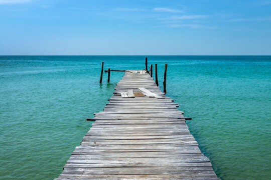 Old jetty over turquoise water on a beach on the island of Koh Rong Sanloem near Sihanoukville, Cambodia