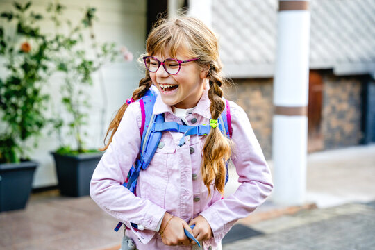 Little Girl on the way to school with a backpack. Happy schoolgirl, back to school concept, walking outdoors with confidence and ready for a new school day