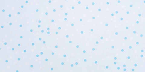 A textured background made of white fabric with a blue polka dot pattern, suitable for use as a background and design element. © Anna