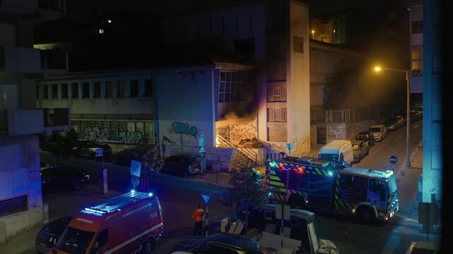 Firefighters responding to a building fire emergency at night