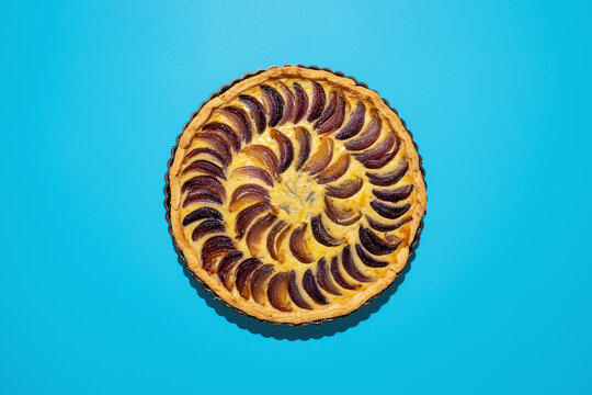 Caramelized onion tart with blue cheese on a blue backdrop