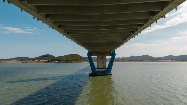 Underside View of a Modern Bridge Over Waterway on Sunny Day