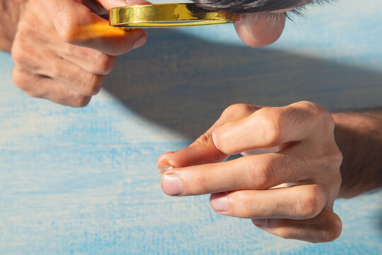 Man examines diamond through a magnifying glass.