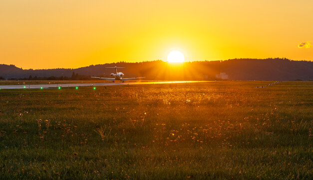 Private jet touching down into a golden sunset