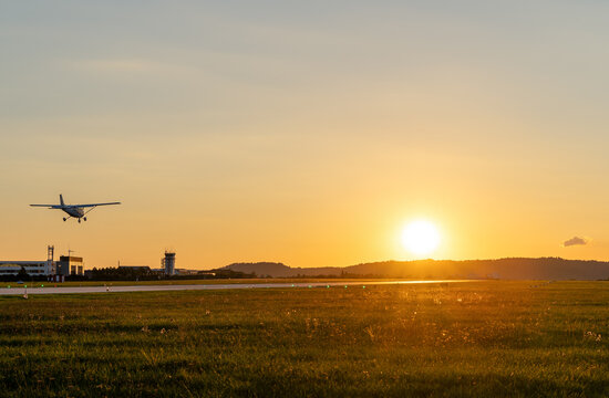 Single-engine aircraft landing at sunset