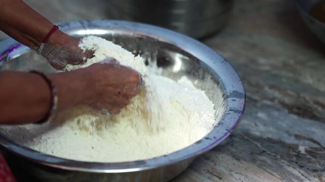 Wheat flour in a metal bowl prepared for traditional Chhath Puja sweets, showing the ingredients and close up details of Indian festival food preparation.