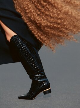 Black crocodile-embossed knee-high boot in fashion pose