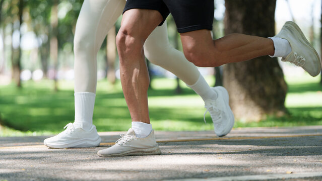 Cropped view of couple legs running together in park for outdoor fitness