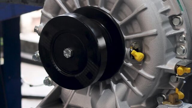 Panning shot of transmission output flange mounted on industrial machinery housing.