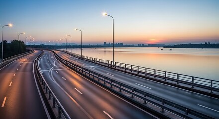 Fototapeta premium Illuminated modern highway bridge extending over calm water at sunset hour