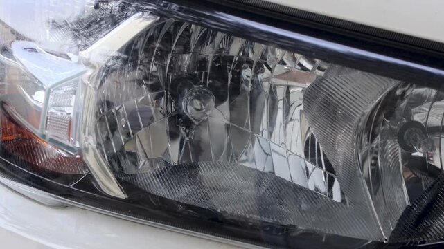 Panning shot of clean car headlight reflector inside automotive maintenance garage.