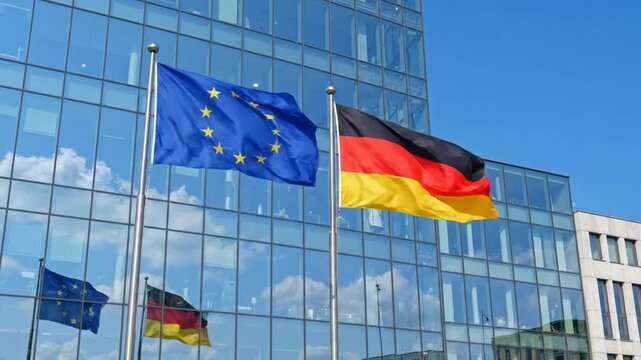 Germany and european union flags waving together in front of modern glass office building political and economic cooperation concept
