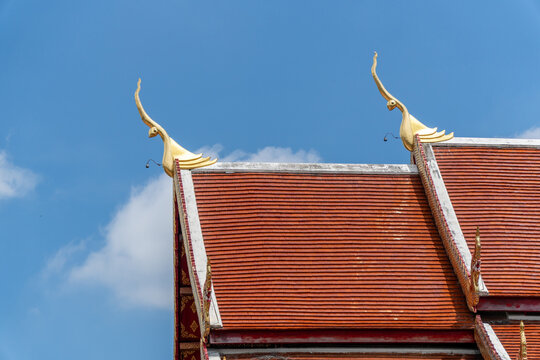 Ornate temple roof with golden finials under blue sky