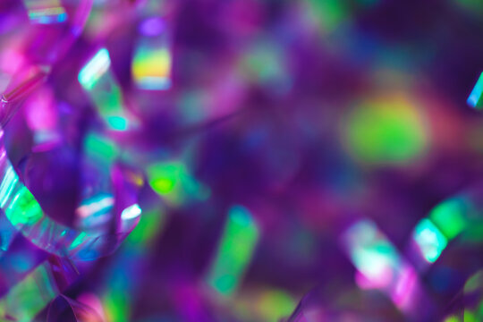 Abstract magenta holographic foil background with high-contrast iridescent shards scattered across a dark indigo surface. Anchors a festive nightclub and retrofuturism design with copy space.