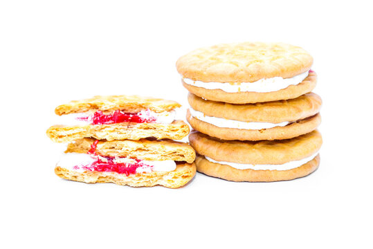Stack of biscuits with sweet cream strawberry jam filling isolated on white background. Golden round cream sandwich with strawberry jam inside