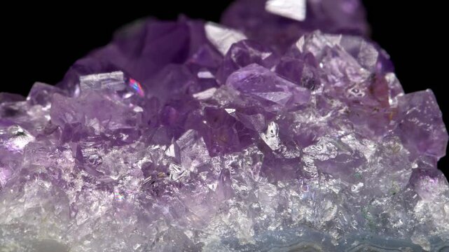 Amethyst (purple quartz) crystals sample against a black background	