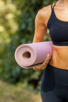 Woman Carrying Rolled Exercise Mat Outdoors for Yoga and Fitness
