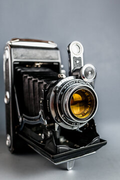 Vintage folding rangefinder camera from the 1950s in excellent condition. Antique analog medium format photo equipment, retro photography history concept backdrop.