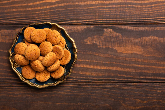 Decorative blue dish filled with traditional Dutch kruidnoten cookies on rustic wooden surface, popular during the Sinterklaas, Saint Nicholas day holiday season, top view with copy space