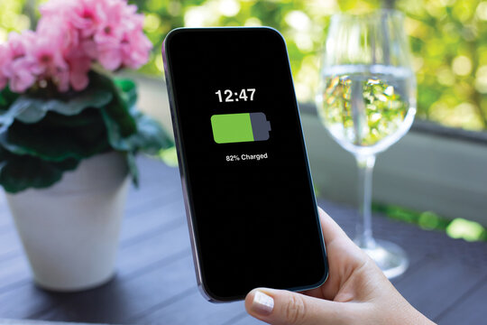 Smartphone battery charging status display held woman hands phone table