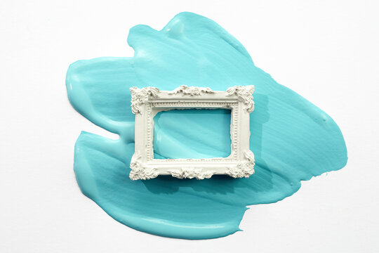 Ornate white frame creating abstract turquoise paint stroke art