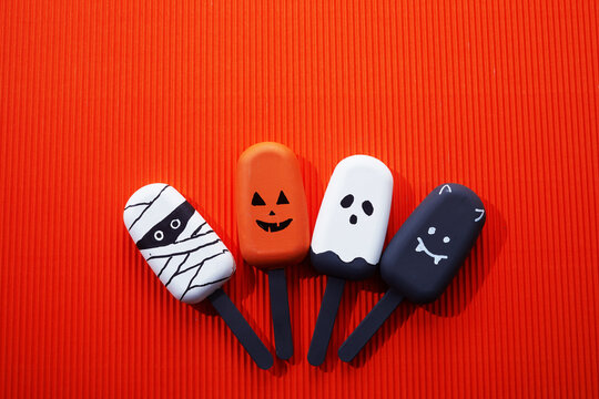 Halloween themed ice cream treats shaped as mummy, pumpkin, ghost, and vampire