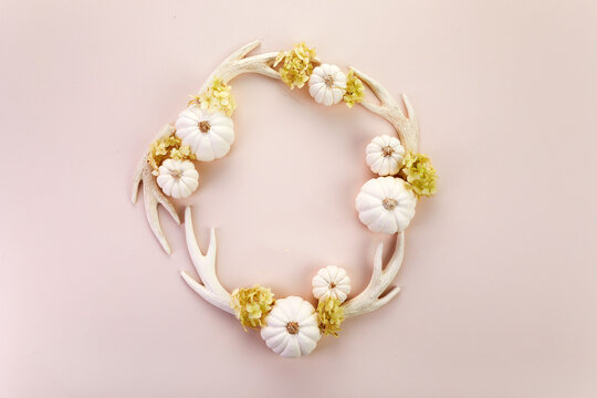 White antlers wreath with mini pumpkins and flowers