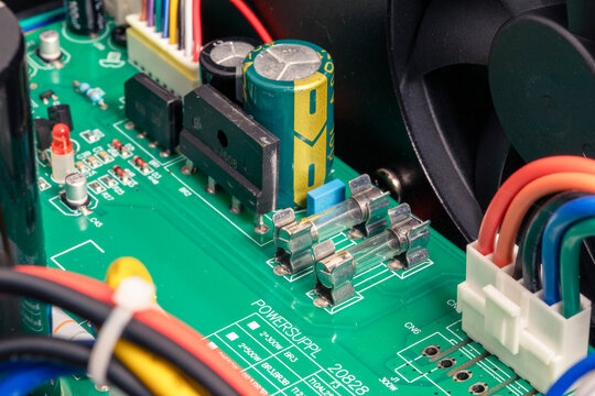 Close-up of electronic circuit board from an amplifier, components include transistors, diodes, resistors, capacitors and fuses.