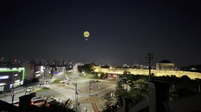 South Korea Night Cityscape with Historic Fortress Wall and Sightseeing Balloon - Moving Traffic at Illuminated Urban Intersection - Travel and Heritage Scene in South Korea