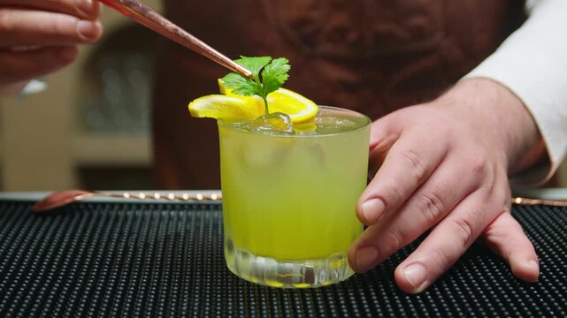 Close Up of Bartender Garnishing Craft Cocktail with Fresh Cilantro