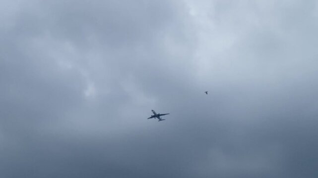 Commercial passenger airplane flying through dark cloudy stormy sky