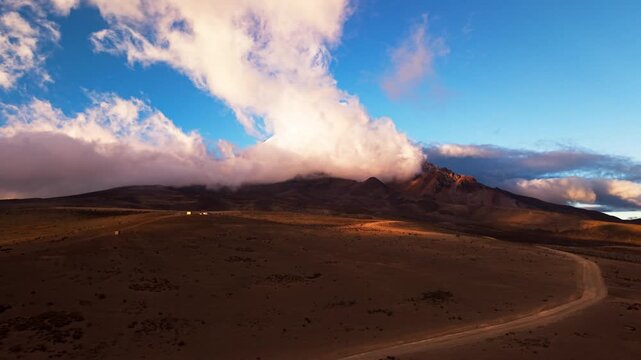 Stunning aerial footage of the majestic chimborazo volcano surrounded by clouds at golden hour