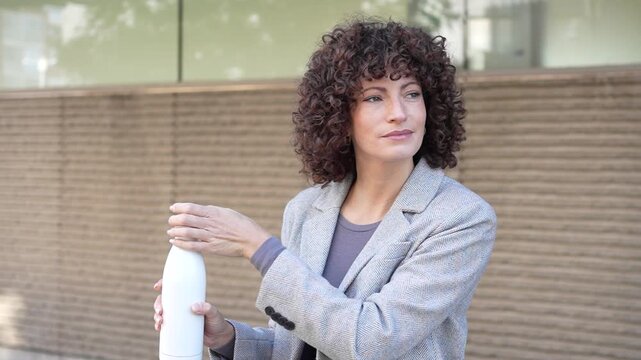 A Confident Woman with Beautiful Curly Hair Posing in a Modern Urban City Setting