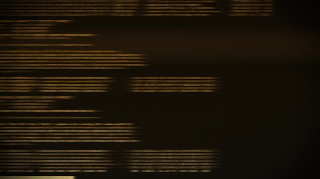Blurred amber computer code moving across dark screen, retro terminal data streaks in orange and gold, hacker, programming and technology background