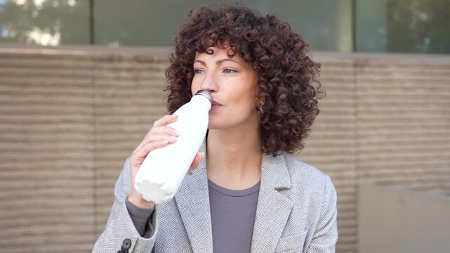 A Relaxed Woman Enjoying a Perfect Moment with a Milk Bottle in the Great Outdoors