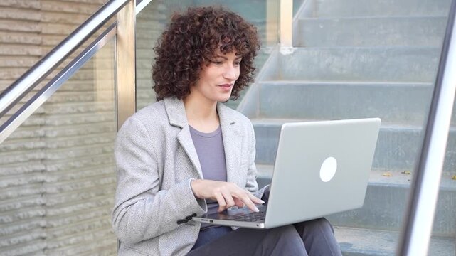 A Professional Woman Actively Engaged in Work on a Laptop While Fully Enjoying the Outdoors