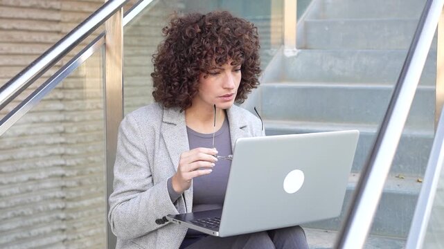 A Focused Woman Diligently Working on Her Laptop in a Modern and Stylish Setting
