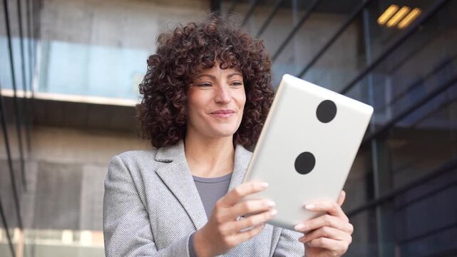 A professional woman is effectively using a tablet in a stylish, modern office environment