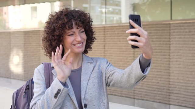 A casual woman enjoys checking her smartphone while outdoors in a vibrant urban environment