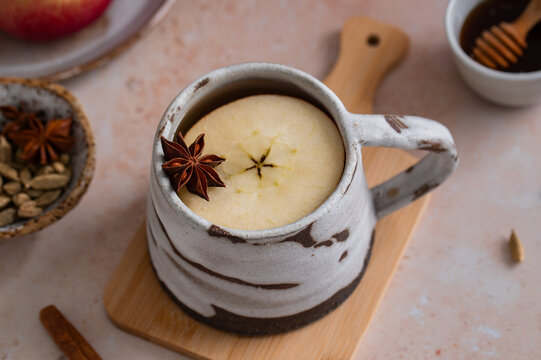 Hot apple cider close-up with anise star, cozy autumn beverage