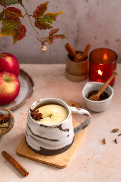 Autumn hot apple cider with spices, cozy hot drink with candle