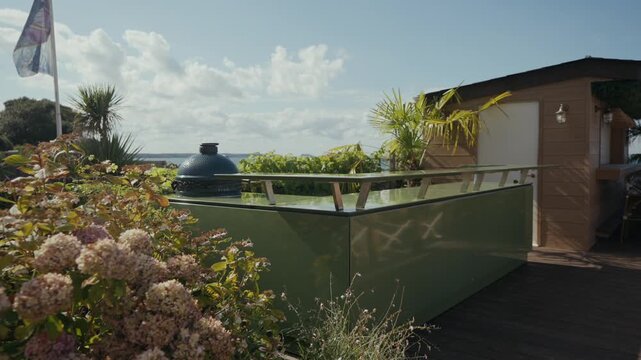Outdoor kitchen with Big Green Egg grill and flowering hydrangea bushes