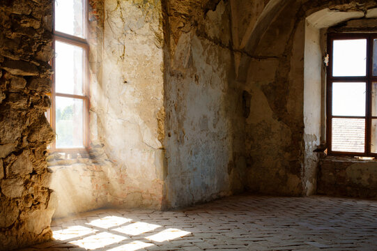 Abandoned interior with sunlight through window and stone architecture