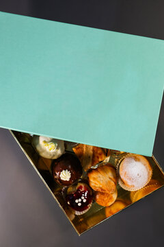 Top view of an elegant pastry gift box filled with assorted Italian desserts, cakes and baked pastries.