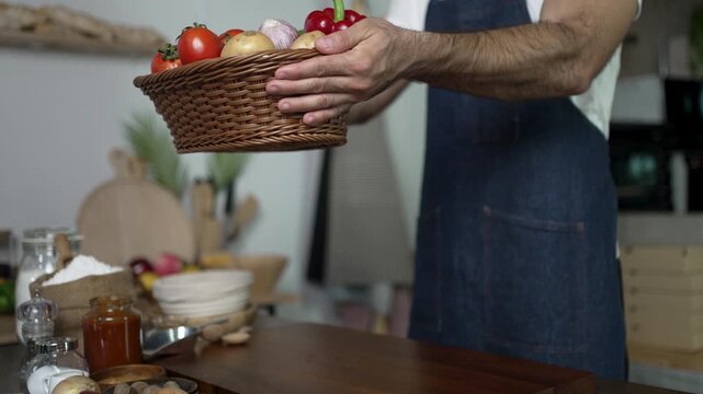 Man Holds Out Basket of Fresh Produce in Kitchen