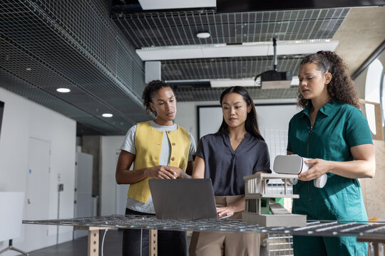 Three Women Collaborating on Innovative Project using augmented reality