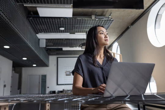 Woman In Thought While Working on Laptop