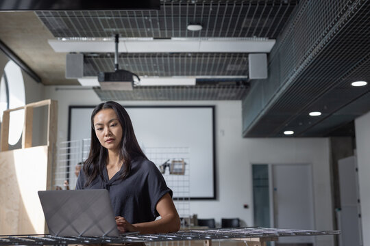 Determined woman using a laptop at her office workspace