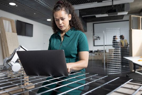 Focused student working with laptop in modern workspace