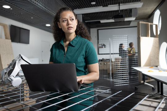 Concentrated student handling tech equipment in modern classroom